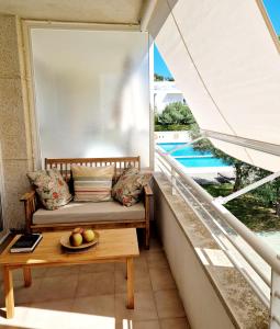 uma varanda com um sofá e uma mesa com uma taça de fruta em Acogedor apartamento en l'Estartit con piscina y Parking em L'Estartit