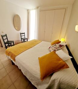 a bedroom with a large bed with two chairs and a window at Acogedor apartamento en l'Estartit con piscina y Parking in L'Estartit