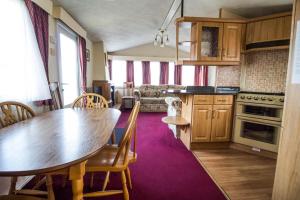 a kitchen with a wooden table and a dining room at 6 Berth Pet Friendly Caravan In Hunstanton By The Beach Ref 13001l in Hunstanton