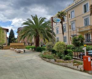 a parking lot in front of a building with palm trees at Appartamento Fiuggi Terme in Fiuggi