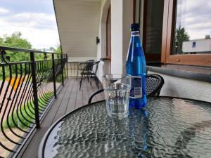 eine blaue Flasche auf einem Tisch mit einem Glas in der Unterkunft Villa Slavia in Chmielno