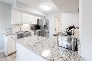 a kitchen with white cabinets and a granite counter top at Turtle Cove 4839 in Kiawah Island