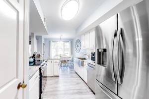 a kitchen with white cabinets and a stainless steel refrigerator at Turtle Cove 4839 in Kiawah Island