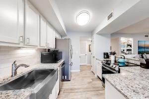 a kitchen with white cabinets and a stainless steel refrigerator at Turtle Cove 4839 in Kiawah Island +9 photos