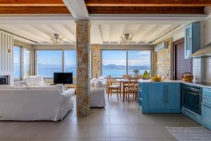 eine Küche und ein Esszimmer mit Meerblick in der Unterkunft Crystal Beach Villa in Chalkida