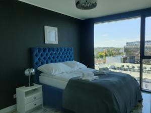 a blue bedroom with a bed and a large window at RS SUITES PRESTIGE 14 piętro "SKY" Racławickie 10 HOME & SPA in Lublin +27 photos