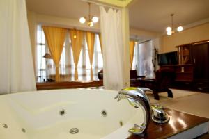 a bathroom with a bath tub with a sink at Hotel Xhema in Pristina