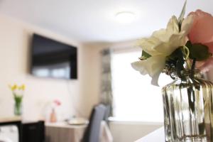 a vase with flowers in it sitting on a table at Self-contained guest suite in Eltham