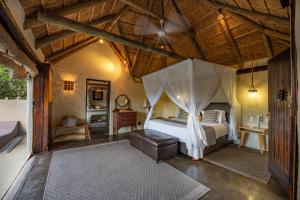 a bedroom with a bed with a canopy at Safari Lodge - Amakhala Game Reserve in Amakhala Game Reserve