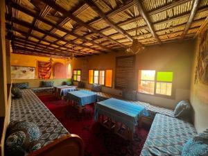 una habitación con mesas y sofás en un edificio en Riad La Fleur, en Aït Baha