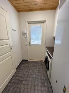 a laundry room with a door and a washer and dryer at Rauhallinen paritalo, Sauna, Terassi, Grilli in Lehmonaho