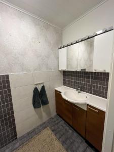 W łazience znajduje się umywalka i lustro. w obiekcie Rauhallinen paritalo, Sauna, Terassi, Grilli w mieście Lehmonaho