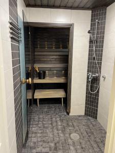 ein Bad mit einer Dusche, einer Badewanne und einem Waschbecken in der Unterkunft Rauhallinen paritalo, Sauna, Terassi, Grilli in Lehmonaho