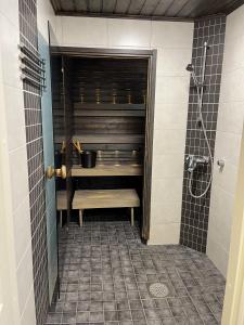 a bathroom with a shower with a tub and a sink at Rauhallinen paritalo, Sauna, Terassi, Grilli in Lehmonaho
