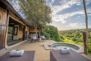 an outdoor patio with a hot tub and a house at Safari Lodge - Amakhala Game Reserve in Amakhala Game Reserve