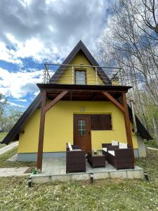 ein gelbes Haus mit Stühlen und einer Veranda in der Unterkunft MELA in Materija
