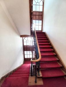 una escalera en un edificio con alfombra roja en Warsaw Concierge Studio Koszykowa, en Varsovia