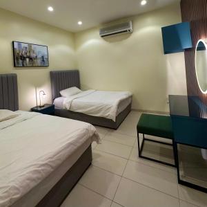 a hotel room with two beds and a mirror at شاليهات كابري وماديرا درة العروس in Durat Alarous