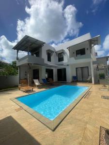 a house with a large swimming pool in front of it at Villa Coco in Trou aux Biches