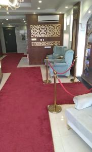 Habitación con alfombra roja, silla y alfombra roja. en فندق اوقات الراحة للوحدات السكنيه, en Tabuk