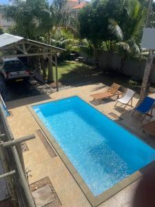 une grande piscine bleue installée à côté d'une maison dans l'établissement Villa Coco, à Trou aux Biches
