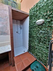 La salle de bains est pourvue d'une douche avec un mur vert. dans l'établissement Mondello Sunrise, à Mondello