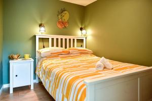 a bedroom with a bed with orange and green walls at Dan Y Coed in Pont-Nedd-Fechan