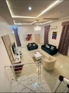 a large living room with a couch and a tv at Jilles apartments -4bedroomduplex24hrlight&security in Lekki