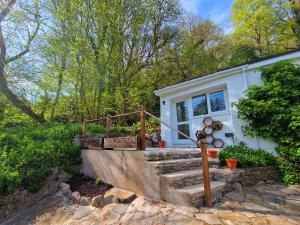 a small white house with stairs and trees at Dan Y Coed in Pont-Nedd-Fechan