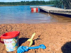 a cup and a plastic spoon in the sand on a beach at PINCIKAJAS Holiday Home in Malveši