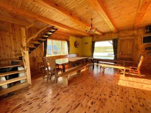 a dining room with a table and stairs in a cabin at PINCIKAJAS Holiday Home in Malveši