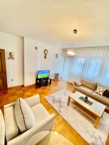 a living room with a couch and a table at Apartment Balcony city view in Pristina