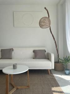 un soggiorno con un divano bianco e un tavolo di Ático duplex Do It Mediterranean a Vinarós