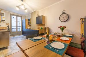 a kitchen and dining room with a table and a clock at L'Authentique - Central - Spacieux - WiFi - Parking Prox in Pézenas
