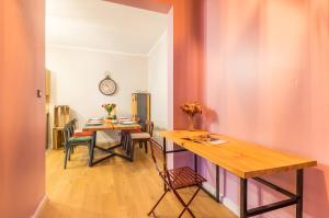 a dining room with a table and chairs and a clock at L'Authentique - Central - Spacieux - WiFi - Parking Prox in Pézenas