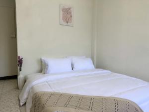 a large white bed with white sheets and pillows at MONTANA Hotel & Hostel Phuket in Karon Beach