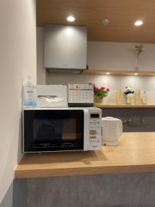a microwave sitting on a counter in a kitchen at Hotel Apreton in Tokyo