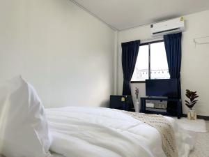 a bedroom with a white bed and a television at MONTANA Hotel & Hostel Phuket in Karon Beach +63 photos