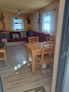 sala de estar con mesa de madera y sillas en le tamarin en Toliara