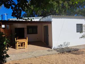 a small white house with a wooden deck at le tamarin in Toliara