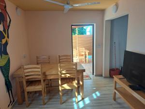 jadalnia ze stołem, krzesłami i telewizorem w obiekcie le tamarin w mieście Toliara