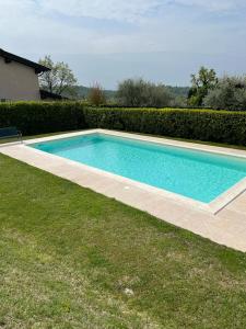 a swimming pool in a yard next to a house at Residence Gli Ulivi in Castion Veronese