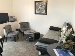 a living room with a couch and a table and chairs at Vue mer à Arromanches in Arromanches-les-Bains