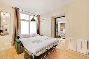 1 dormitorio con cama y ventana grande en Superb apartment 4 people center of Paris, en París