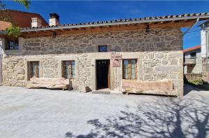 un edificio de piedra con una puerta delante en La Cantina casas rurales paredes en Villar de Corneja