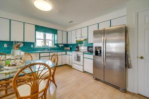 a kitchen with a table and a stainless steel refrigerator at Topsail Beach Vacation Rental Steps to Shore! in Topsail Beach