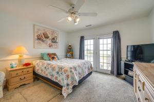 a bedroom with a bed and a flat screen tv at Topsail Beach Vacation Rental Steps to Shore! in Topsail Beach