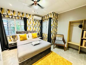 une chambre avec un lit et une chaise dedans dans l'établissement Luxurious Villa Pool Hot Tub and Bar, à Apenkwa 33 autres photos