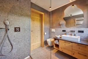 uma casa de banho com um lavatório e um chuveiro em Bichl Ferienwohnungen em Krün