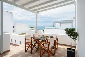 a dining room with a table and chairs on a balcony at Erato Inn Naxos in Agios Prokopios